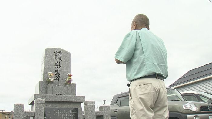 慰霊碑に手を合わせる尾田光吉さん
