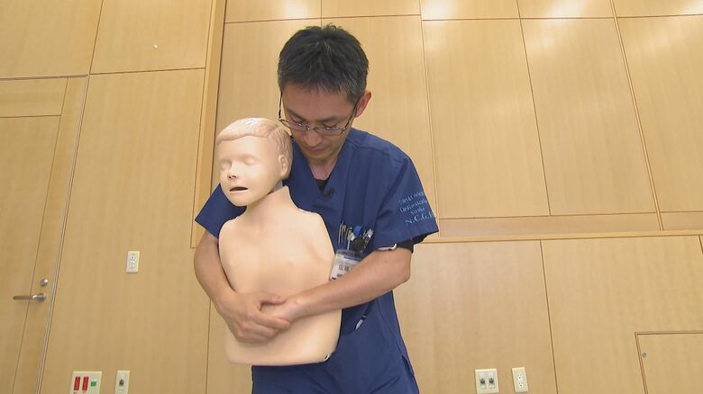 みぞおちの前で両手を組み押す