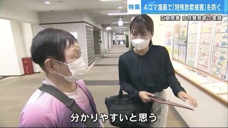 訪れた人に4コマ漫画を紹介する石川さん