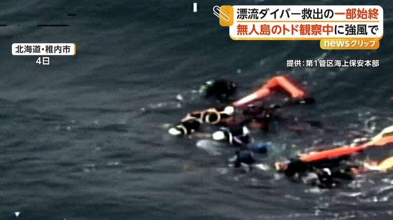 肩を寄せ合うように浮具につかまり、波に揺られるダイバーたち