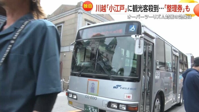 車道にはみ出した観光客のすぐ横をバスが走り抜ける場面も