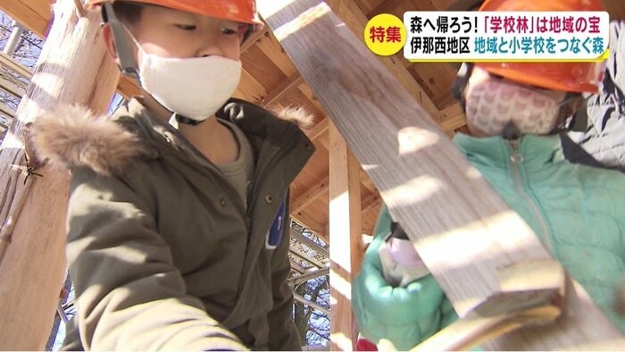 木材の防腐剤を塗る児童