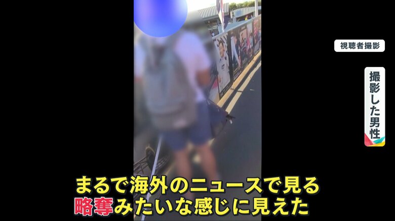 通路の端でのぼりを外す人