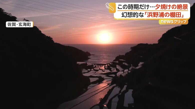 差し込む夕日と海岸に向かって伸びる棚田が作り出す幻想的な風景（8日、佐賀・玄海町）