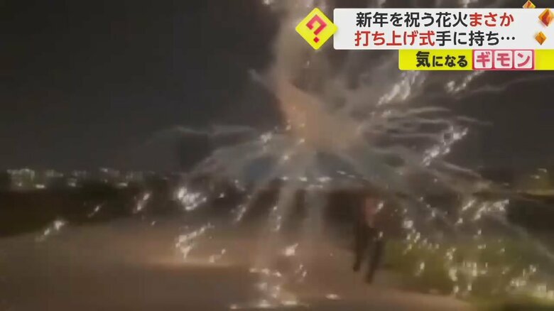 打ち上げ花火が男性の手の中で爆発する瞬間⑤