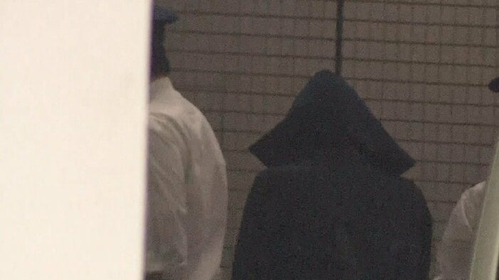 千葉地検に入る岡田容疑者。頭からフードで覆い、表情を見ることはできなかった(13日)
