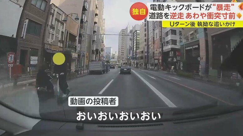 停車中のトラックの脇から電動キックボードが現れ、逆走状態で原付バイクに突っ込む