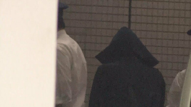 千葉地検に入る岡田容疑者。頭からフードで覆い、表情を見ることはできなかった(13日)