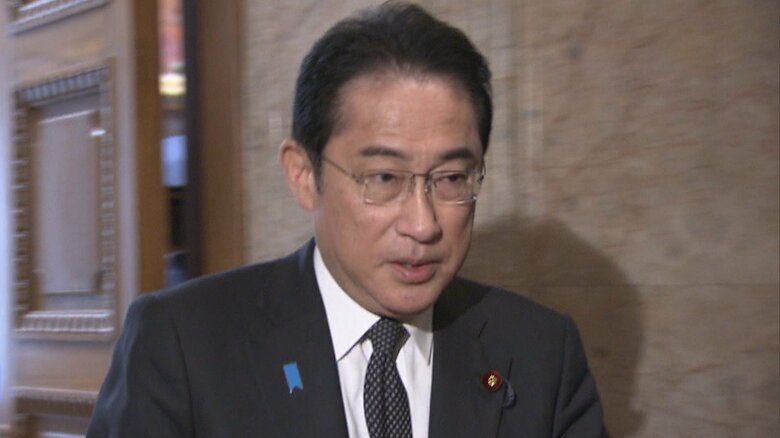参院本会議場に向かう岸田首相（26日午前）