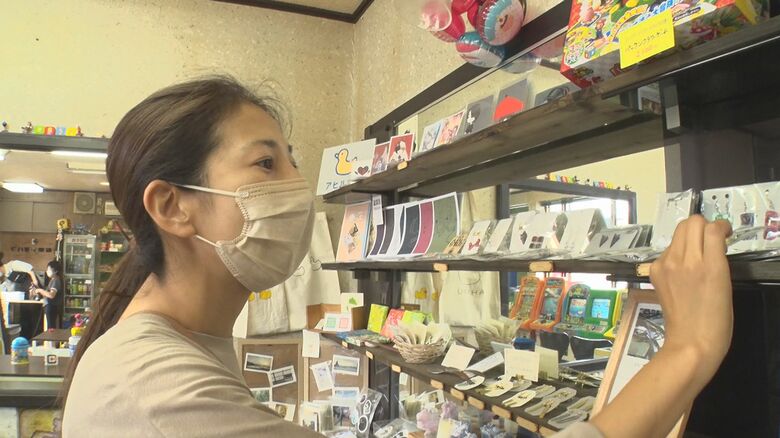学生の作品を手に取るお母さん