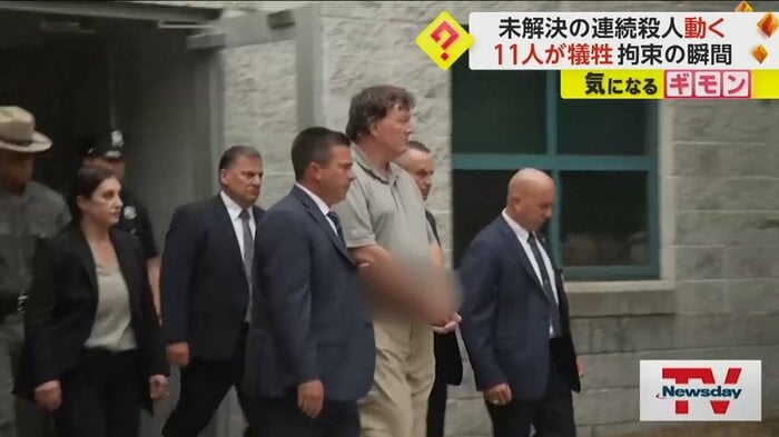 大柄な男が警察官に連れられている
