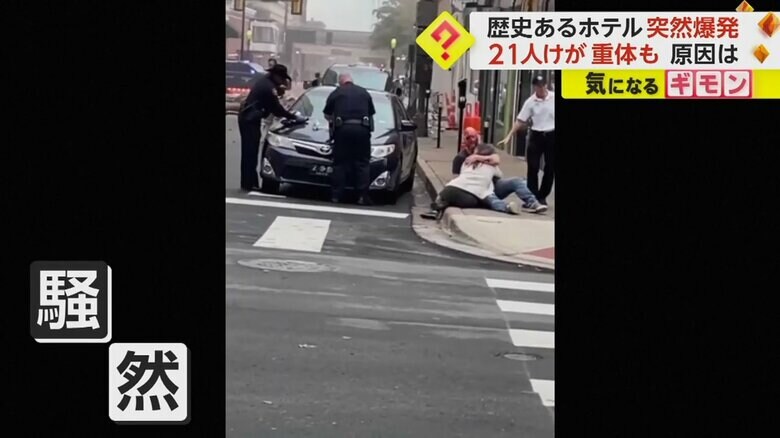 現場近くの歩道にしゃがみ込む人の姿