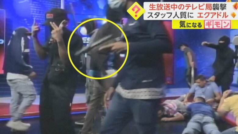 手に銃を持つ武装集団。テレビ局スタッフは床に伏せている