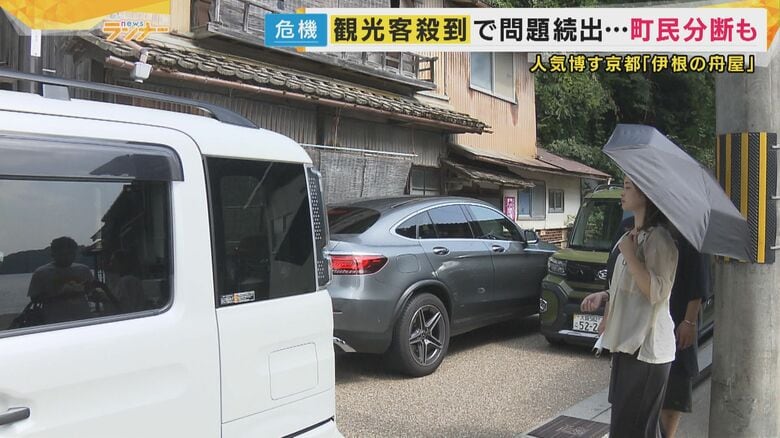 狭い路地に多くの車と人が行き交う