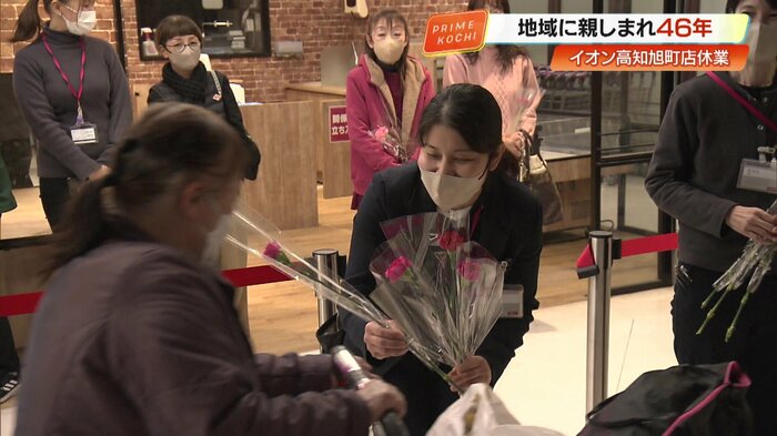 最終日の利用客へ感謝を込めて花を手渡す安並店長