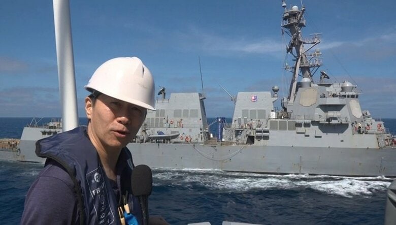 アメリカ軍のミサイル駆逐艦のそばでリポートをする筆者