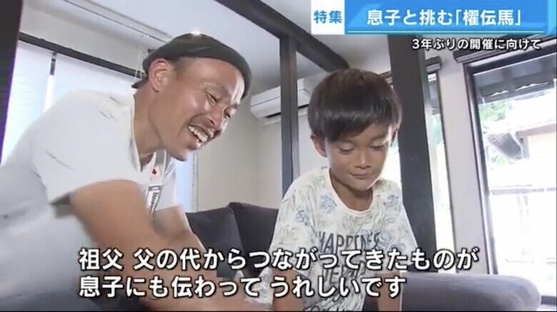藤原さんが剣櫂を務めていたころの写真を見る息子の海月くん(8)