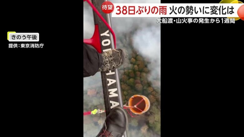ヘリの真下にぶら下げられたオレンジ色のバケツで放水