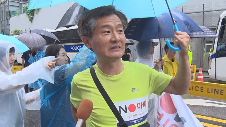 日本大使館前の集会に参加した男性 胸には「NO安倍」の文字が
