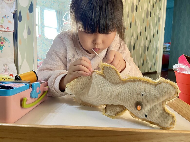 くわえたばこならぬ「くわえアメ」で作業する娘さん