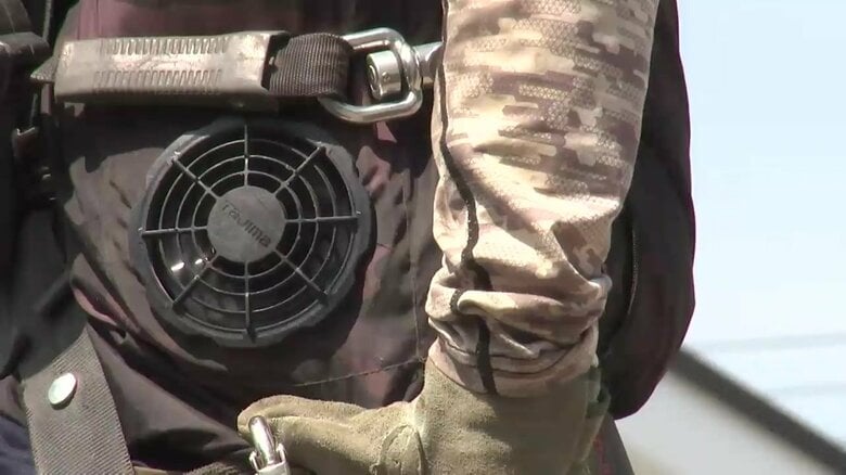 屋外で作業にあたる作業員にファン付きウェアを支給