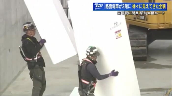 大きな発泡スチロールブロックを運ぶ作業員