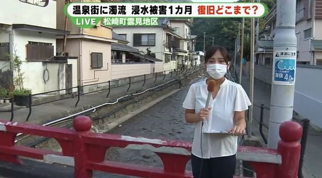 台風で氾濫した川でリポートする雨宮記者