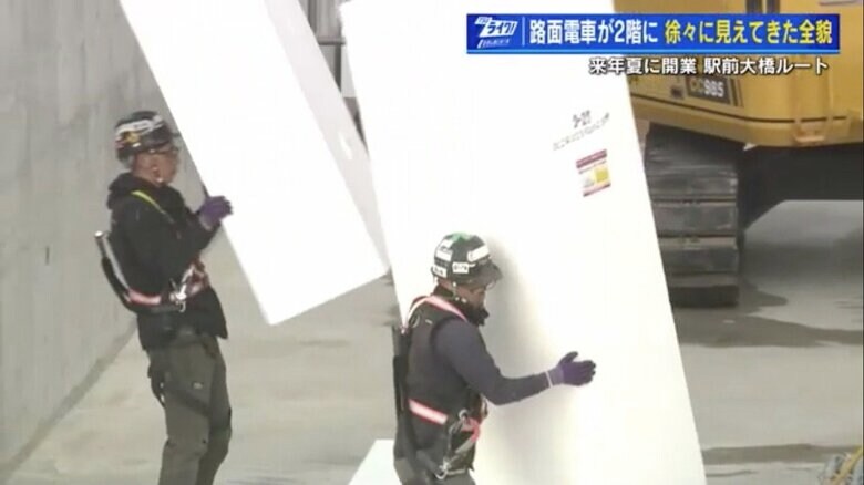 大きな発泡スチロールブロックを運ぶ作業員