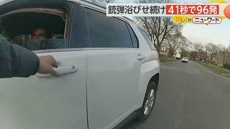 男の白い車を開けようと扉に手をかける警察官