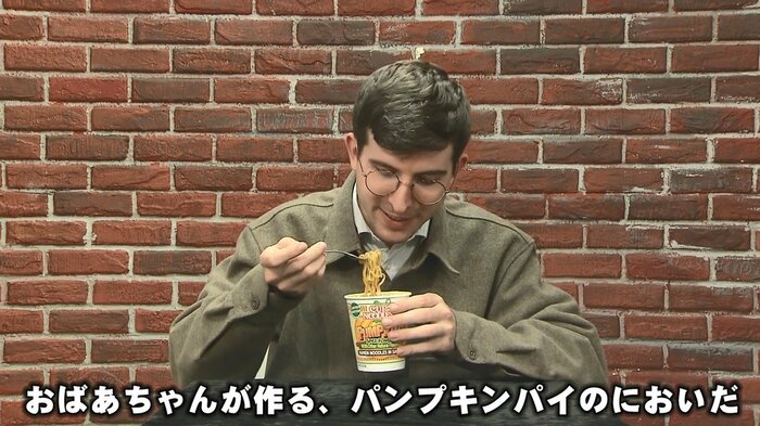 パンプキンスパイス風味のカップ麺を試食するリポーター