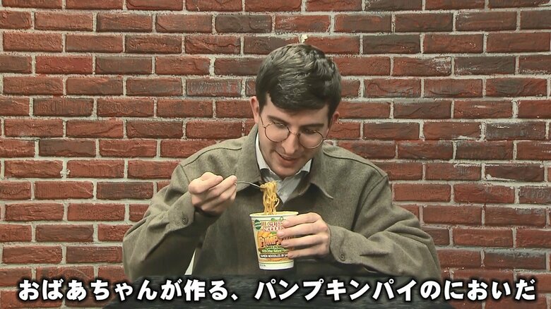 パンプキンスパイス風味のカップ麺を試食するリポーター