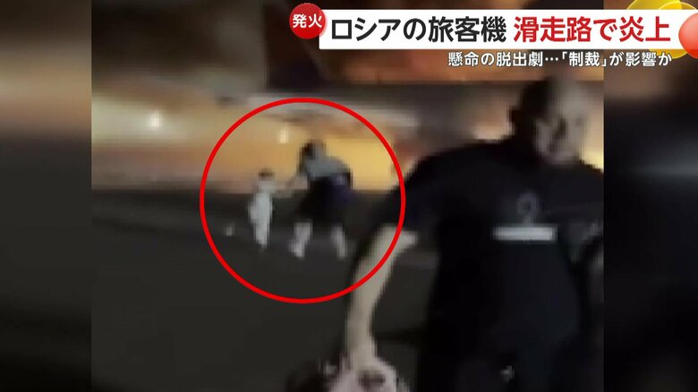 子供の手を引いて機体から離れる乗客