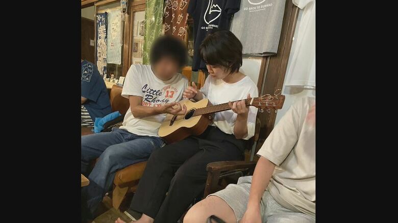 ゲストハウスでギターを教えてもらう村上さくらさん