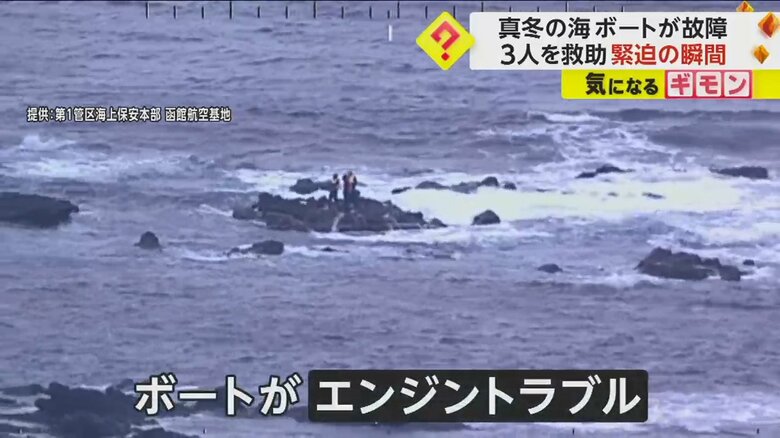 波しぶきがあがる海で岩場に立っている3人