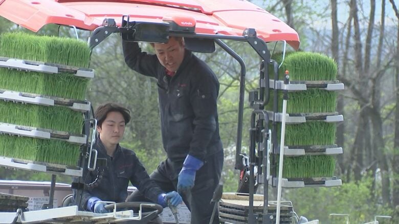 親子で田植え機に乗り息子に操作方法を教える立柳さん