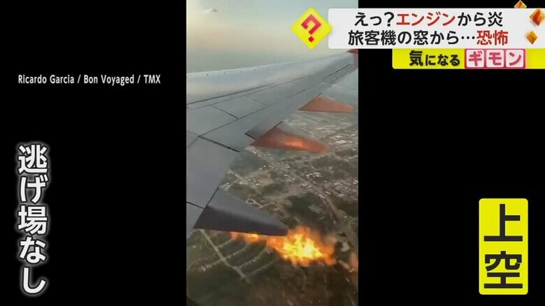 飛行中の旅客機のエンジンから火が噴き出している