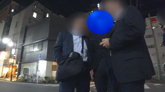 捜査員に両脇を抱えられる男