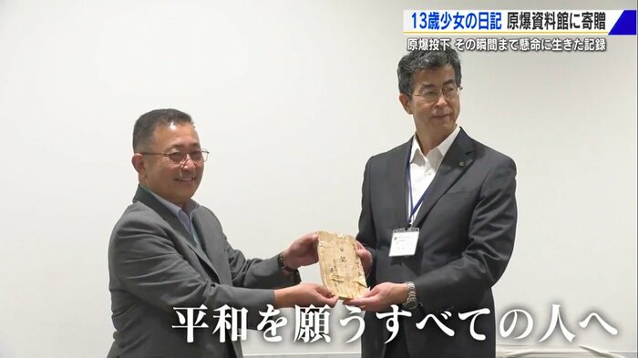 瑤子さんの遺品を手渡す細川洋さん(左)