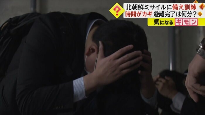 身を低くして頭を抱える職員