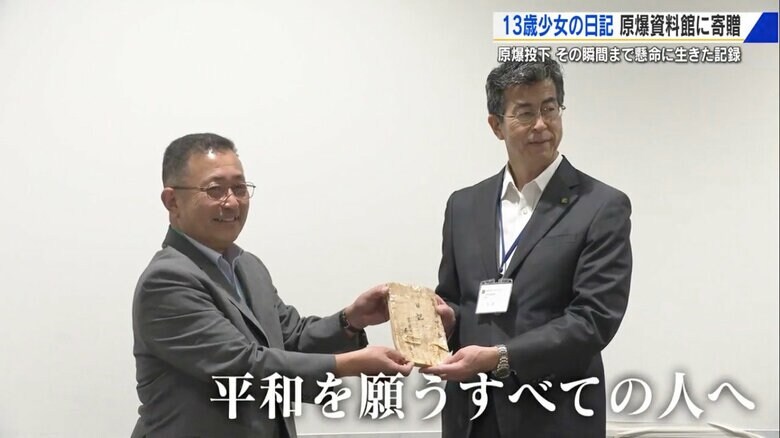 瑤子さんの遺品を手渡す細川洋さん（左）