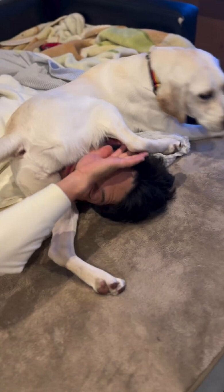 片手で足をのけようとする旦那さん