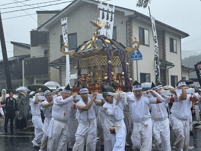 雨の中、大きな神輿が街中を練り歩いた