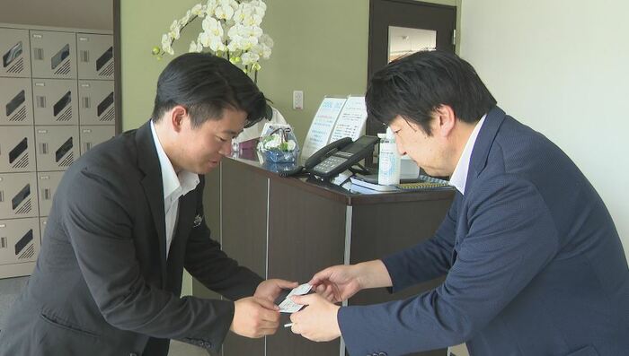 取引先を訪問する北澤以進さん（左）