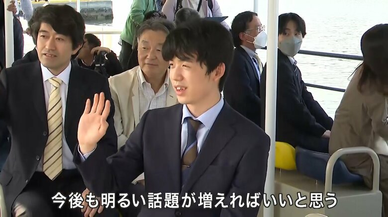 遊覧船から訪れた人に手を振る藤井六冠