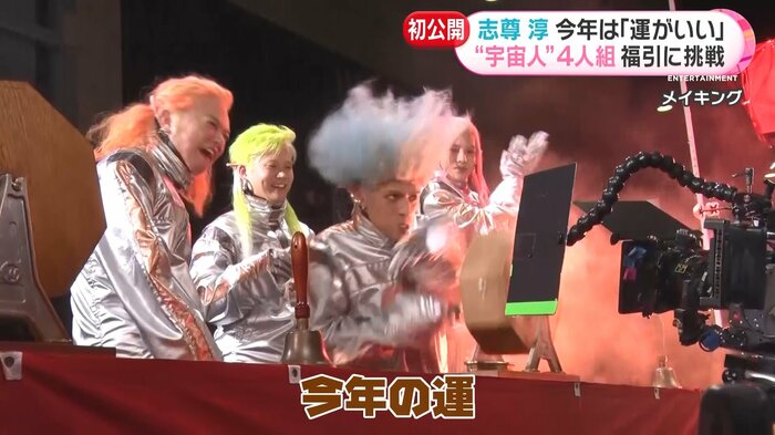 全力で抽せん機を回す4人