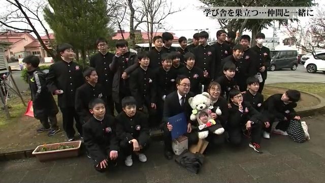 記念撮影をする同級生 ぬいぐるみの学生服は母・幸枝さんの手作りだという