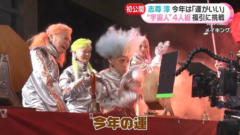 全力で抽せん機を回す4人
