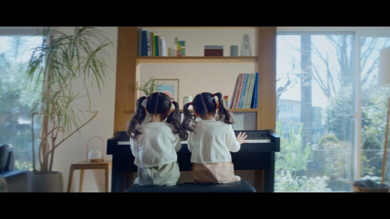 お揃いの服で連弾する双子の娘たち