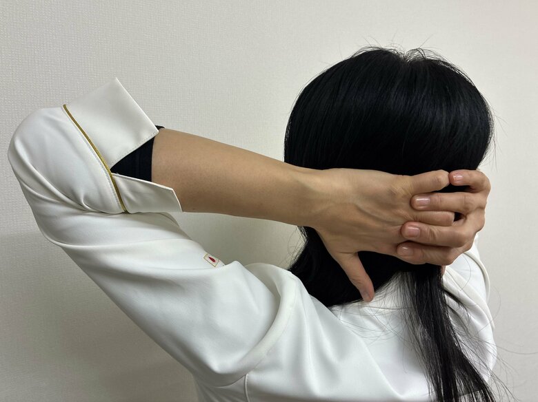 指にもたれかかるように後頭部を押し当てる（特集班撮影）