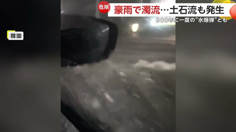 韓国で川のようになった道路を進む車
